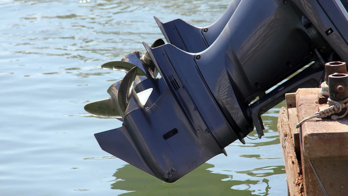Outboard lower unit tilted up beside a wooden dock