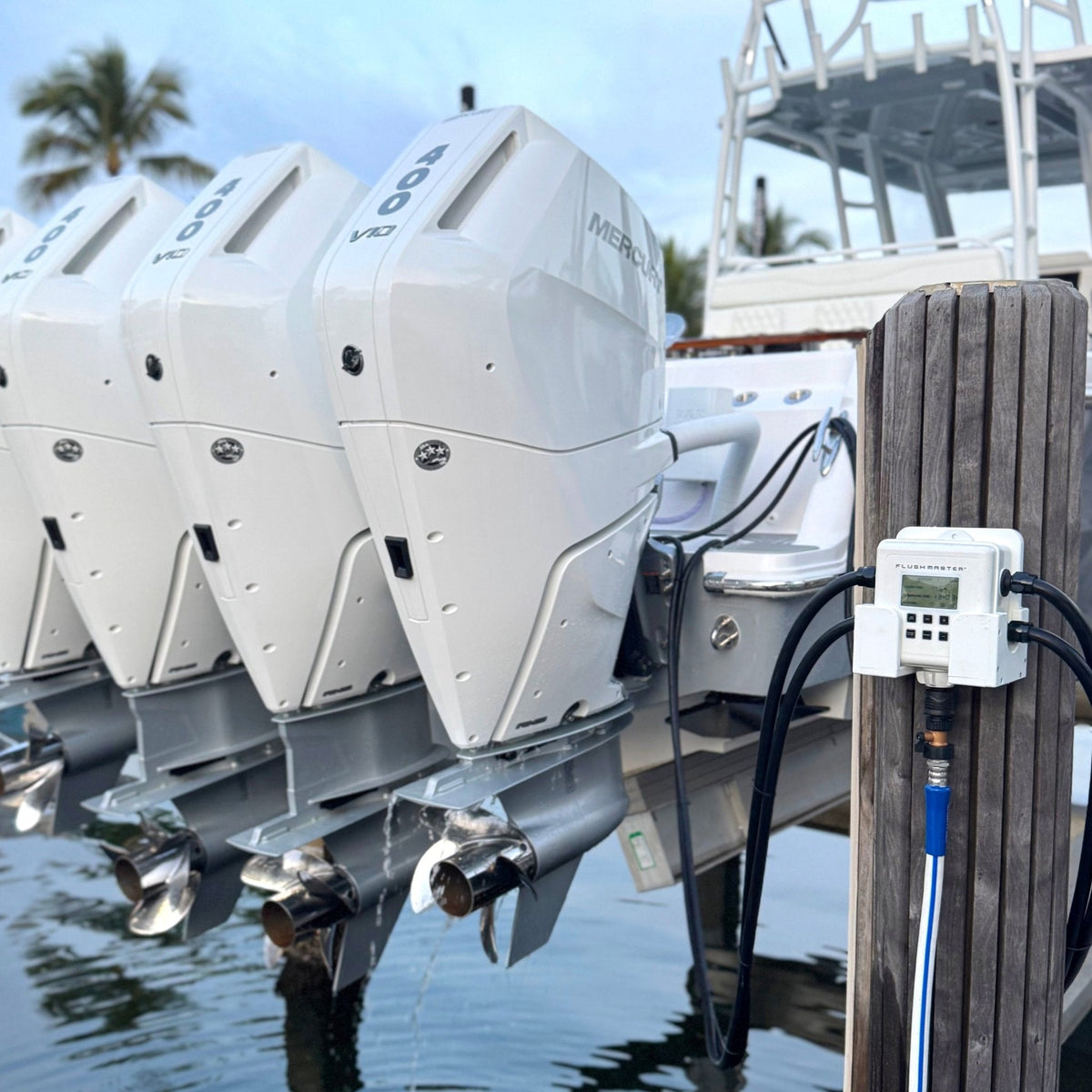 Quad white Mercury outboards connected to a dock-mounted Flushmaster Controller