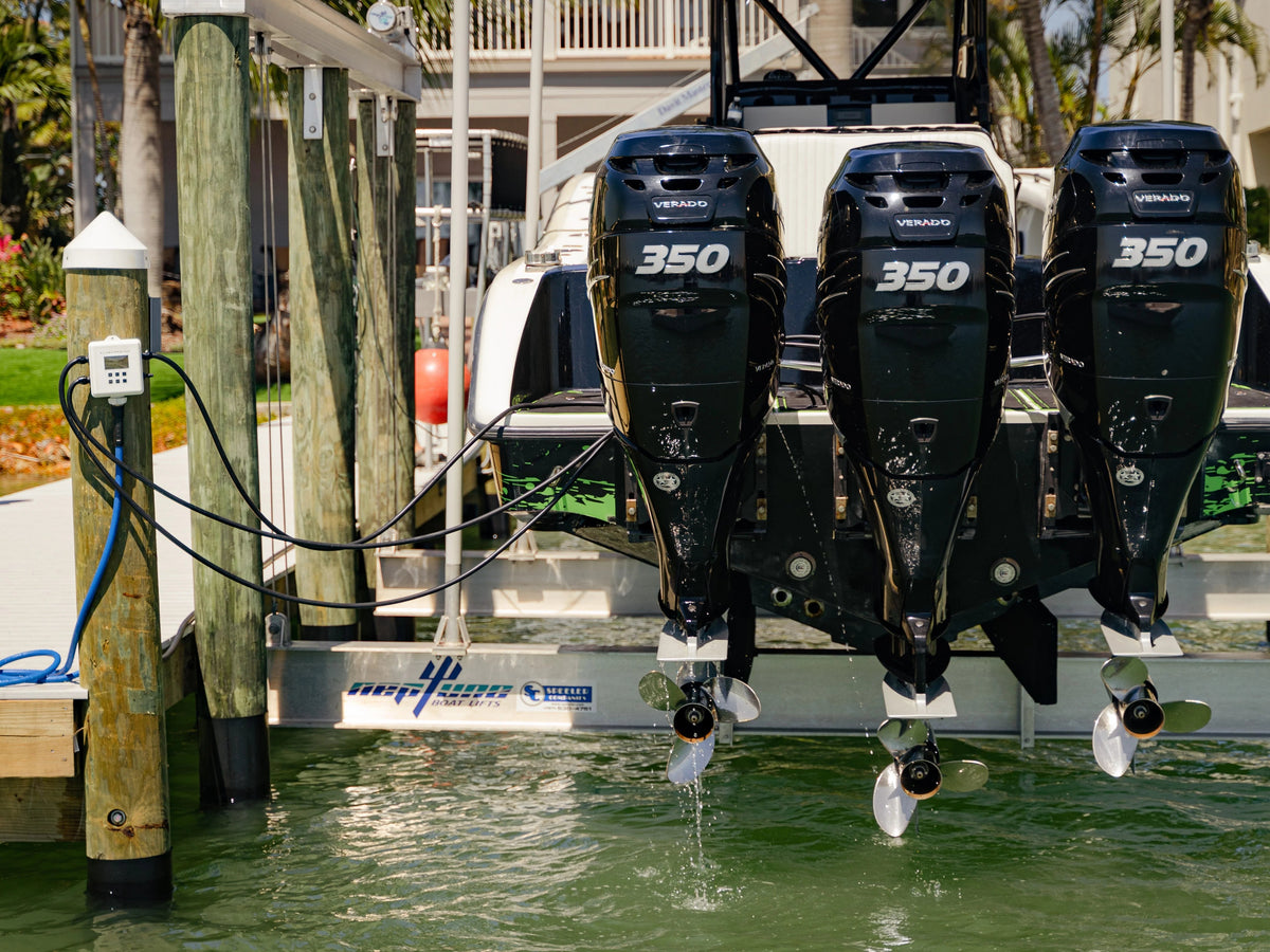 Three Suzuki 350 outboards on a boat lift with a Flushmaster Controller nearby