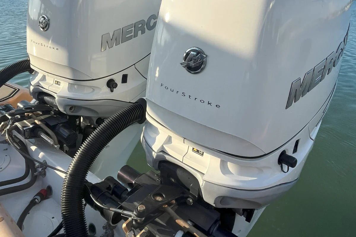 Twin white Mercury outboards with flush connections at the stern