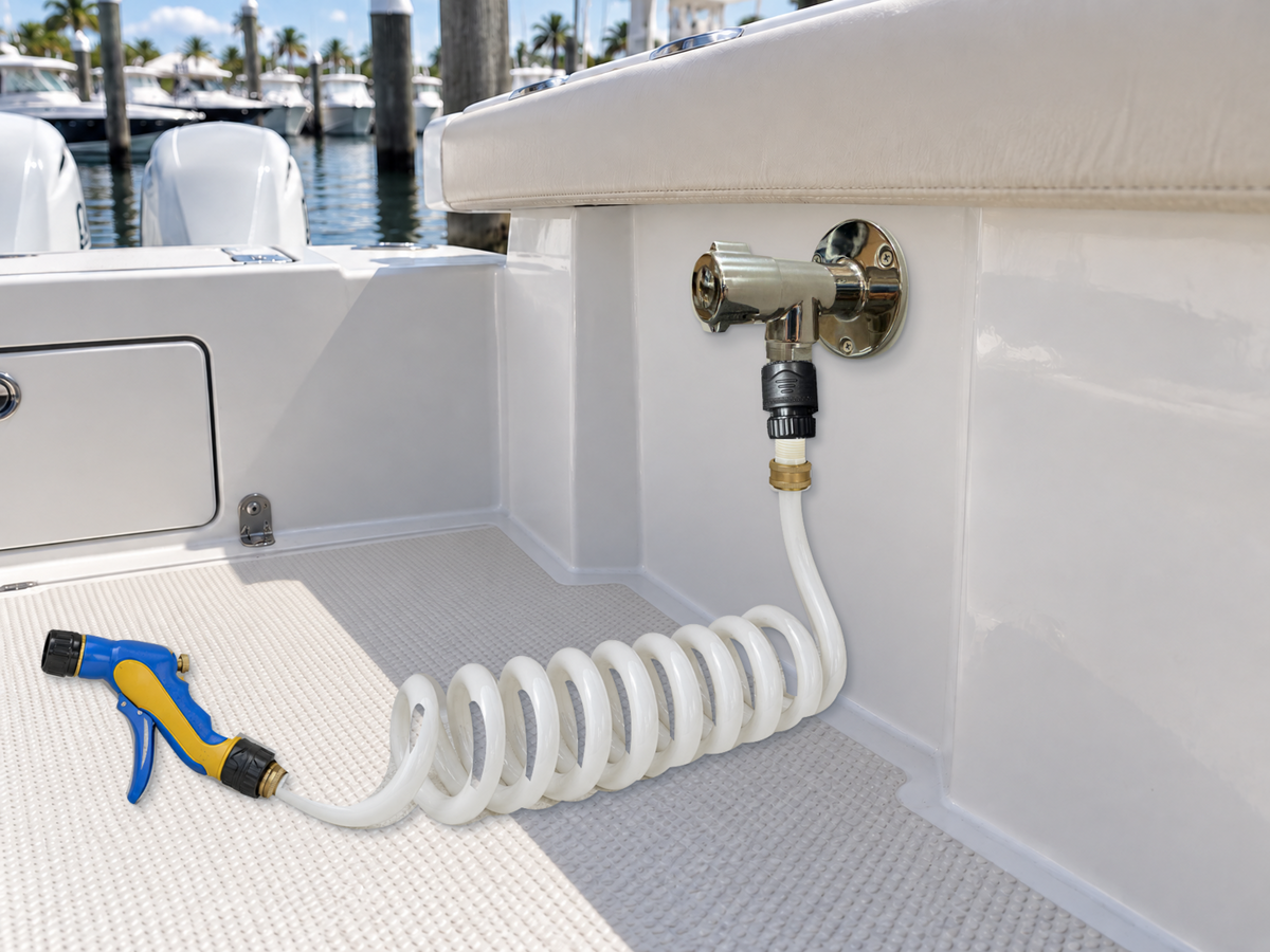 Illustrative 90-degree Flushmaster Water Spigot installation with a coiled washdown hose and spray nozzle in a boat cockpit.