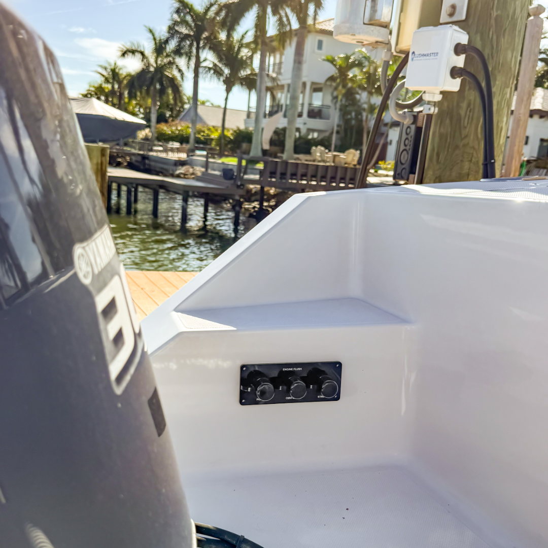 triple black acrylic flush port reroute installed on white boat showing dock and flushmaster controller