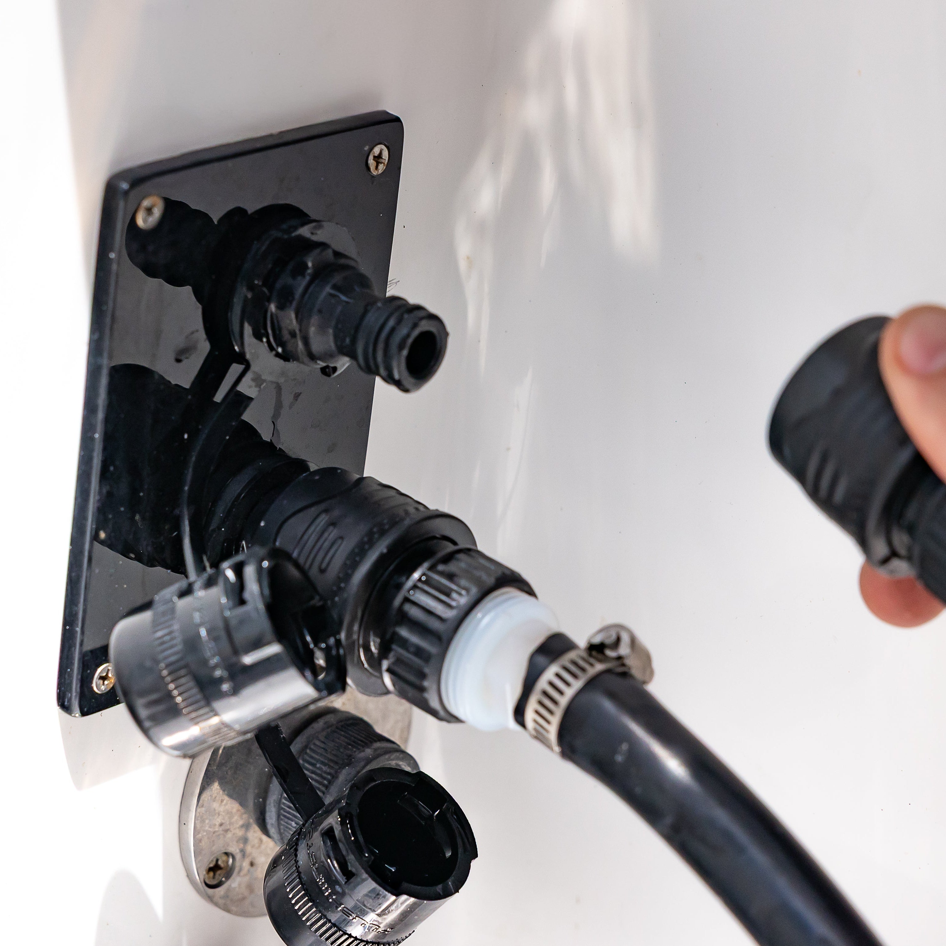 hand connecting quick connect to black acrylic reroute outlet