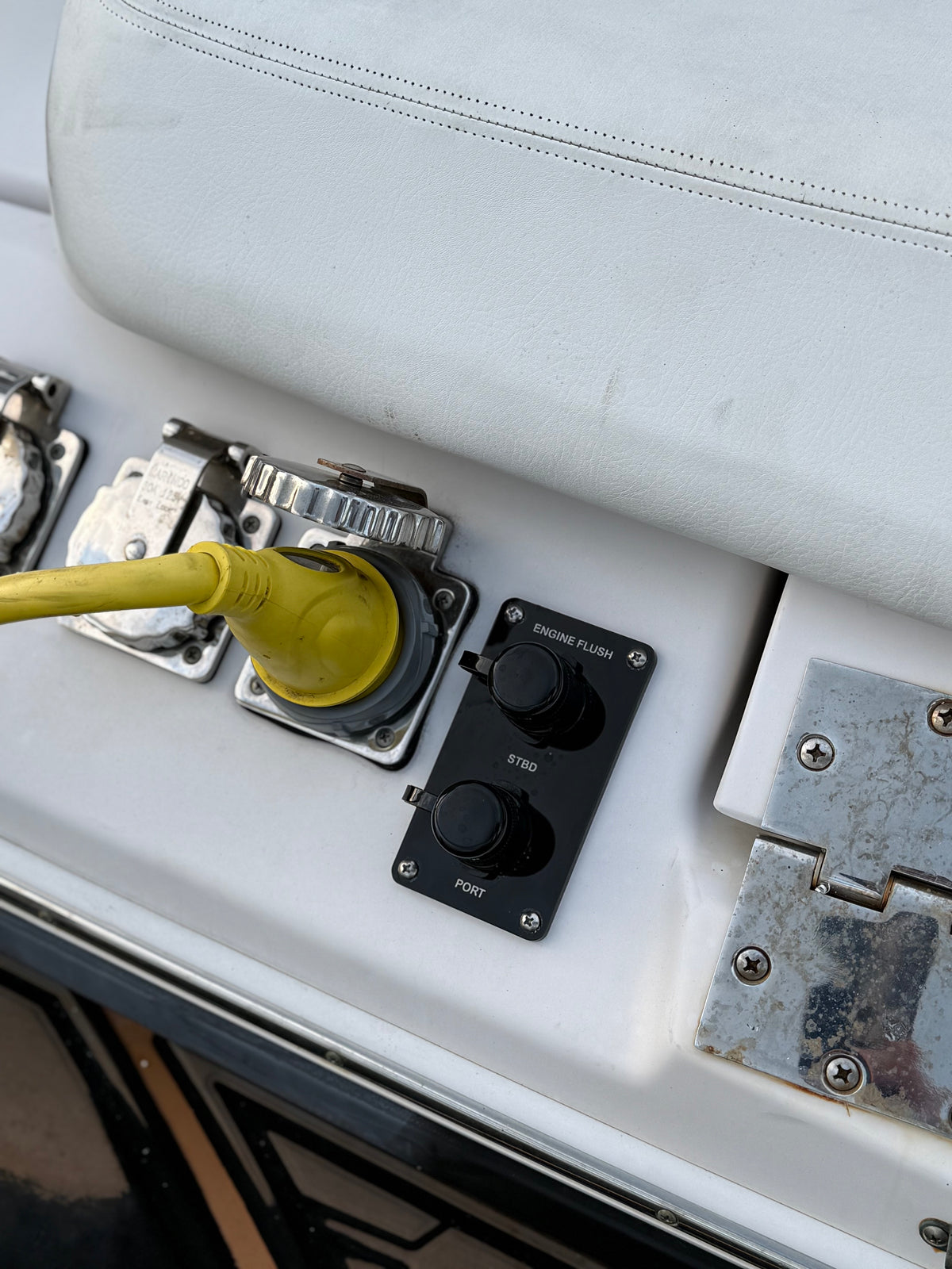 Dual black Flush Port Reroute mounted vertically below a boat's seat, with both locking caps closed.