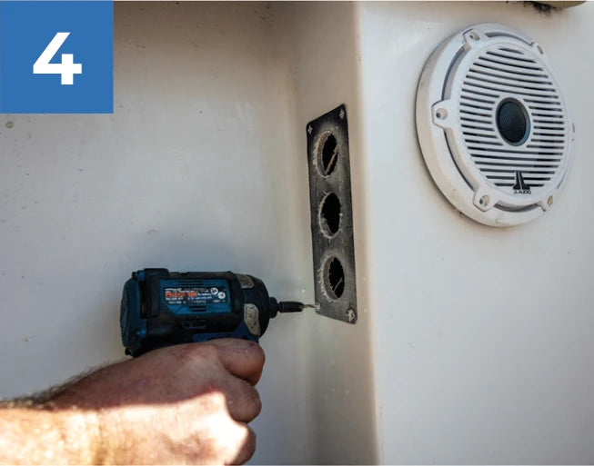 Drilling a mounting pilot hole beside the Reroute plate’s plumbing openings