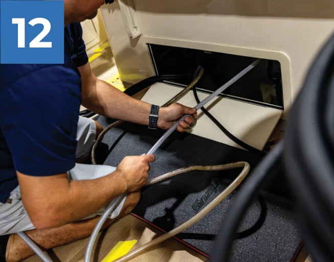 Routing the new hose inside the boat toward the reroute mounting location.