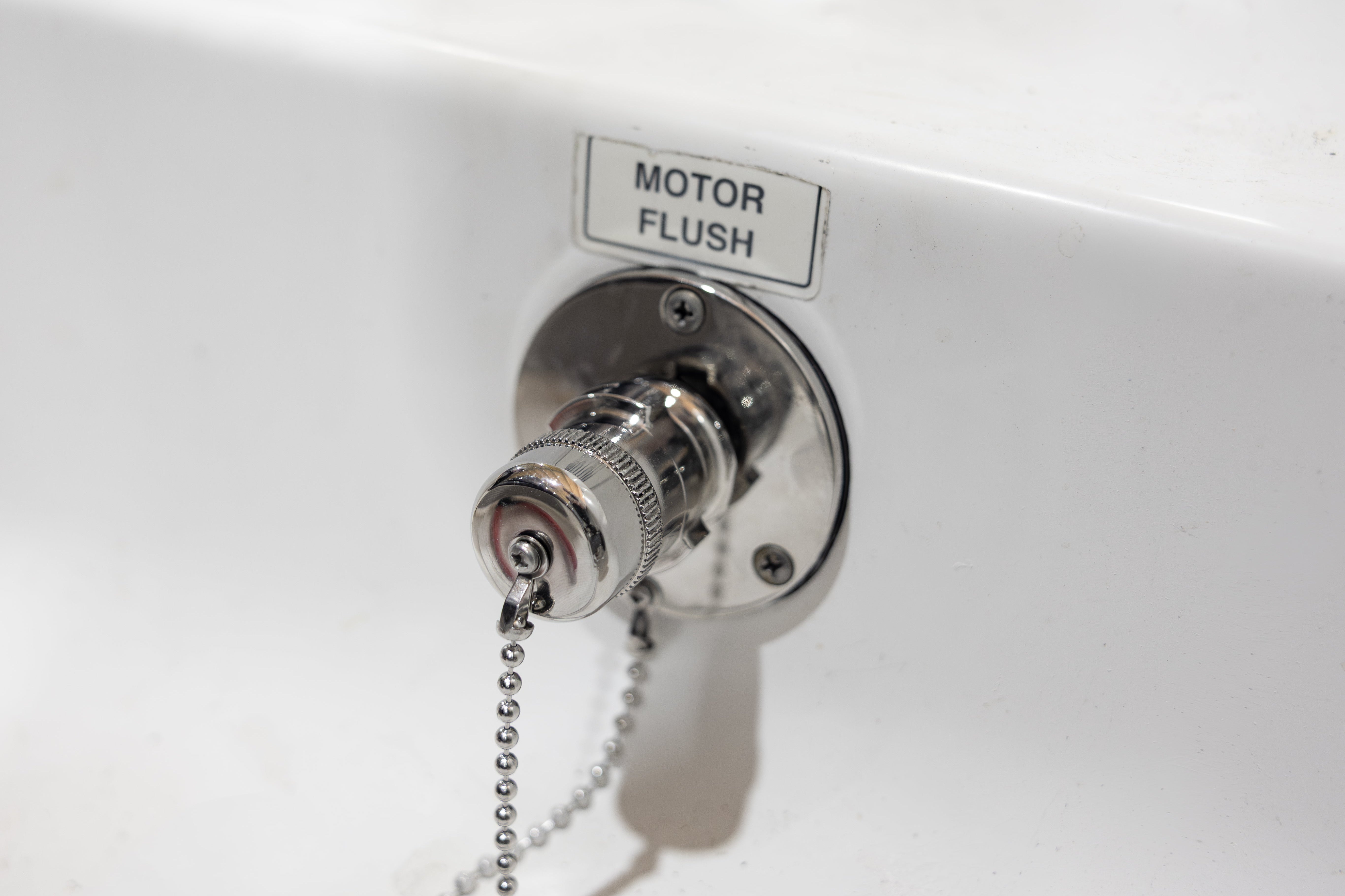 close up of rerouted outboard engine flush connection quick connect fitting