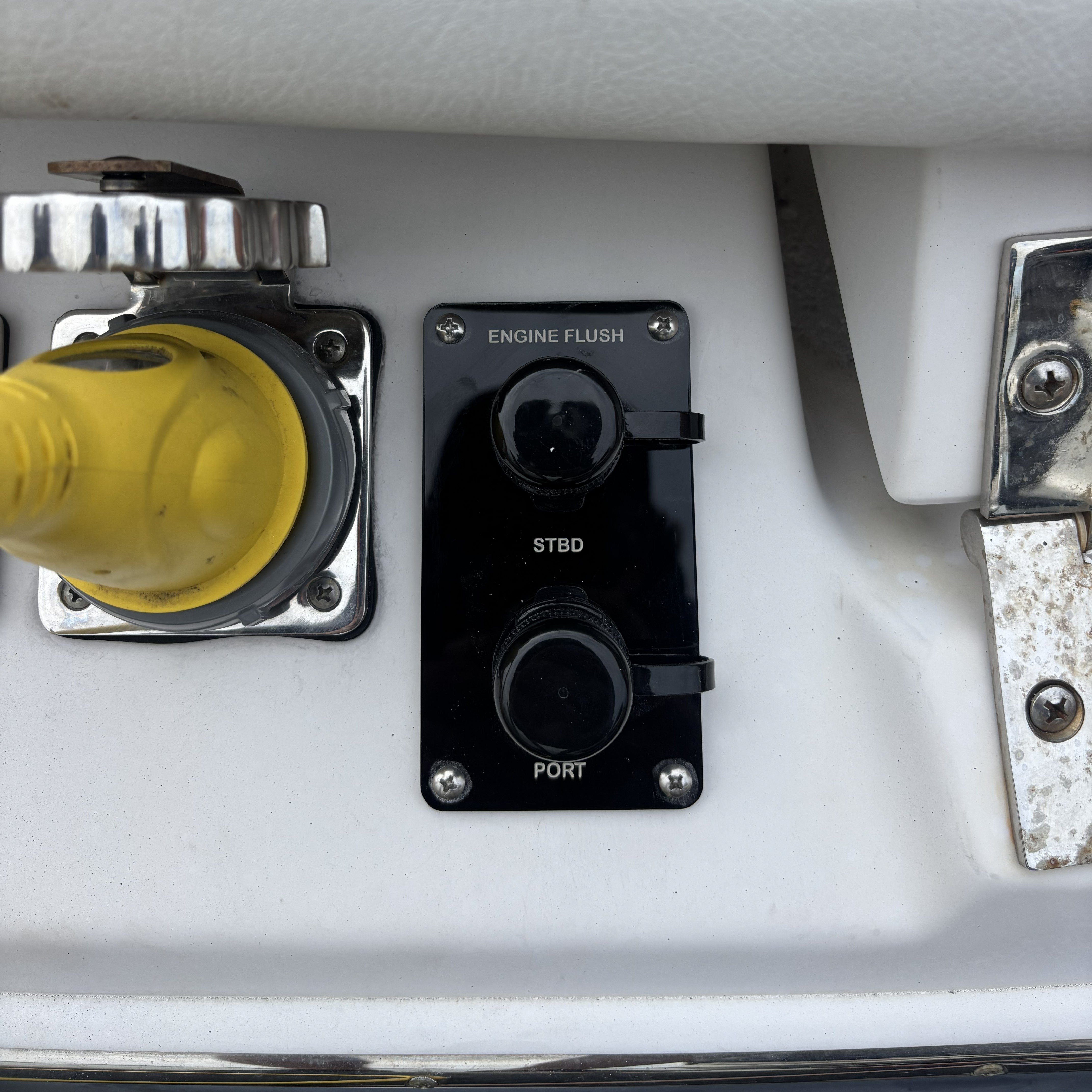 black acrylic dual outlet flush port reroute installed on white boat with dual mercury outboards