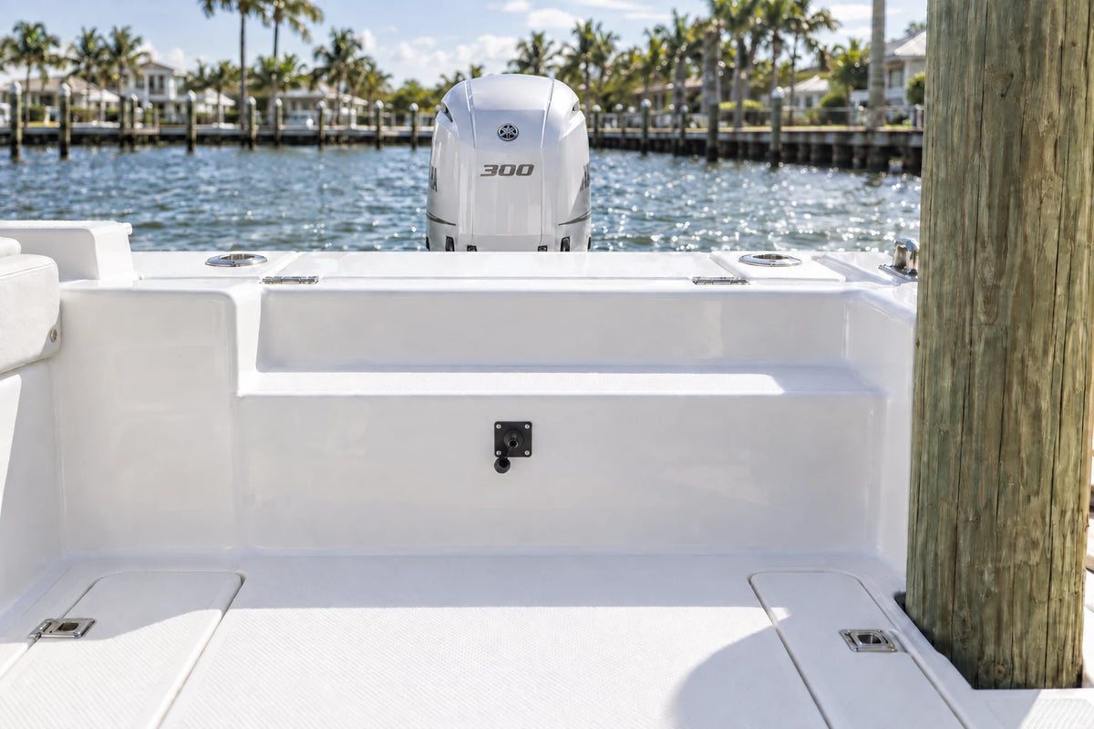 Illustrated black 1-outlet Flush Port Reroute mounted horizontally in a boat cockpit with 1 outboard engine and open locking caps