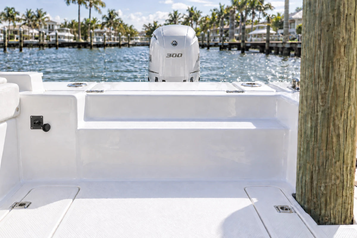 Illustrated black 1-outlet Flush Port Reroute mounted vertically in a boat cockpit with 1 outboard engine and open locking caps