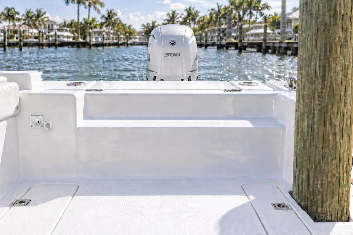 Illustrated white 1-outlet Flush Port Reroute mounted vertically in a boat cockpit with 1 outboard engine and open locking caps