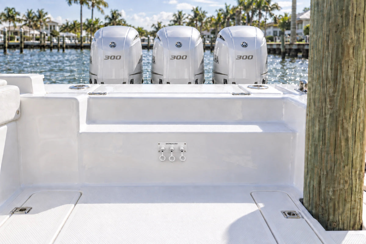 Illustrated white 3-outlet Flush Port Reroute mounted horizontally in a boat cockpit with 3 outboard engines and open locking caps