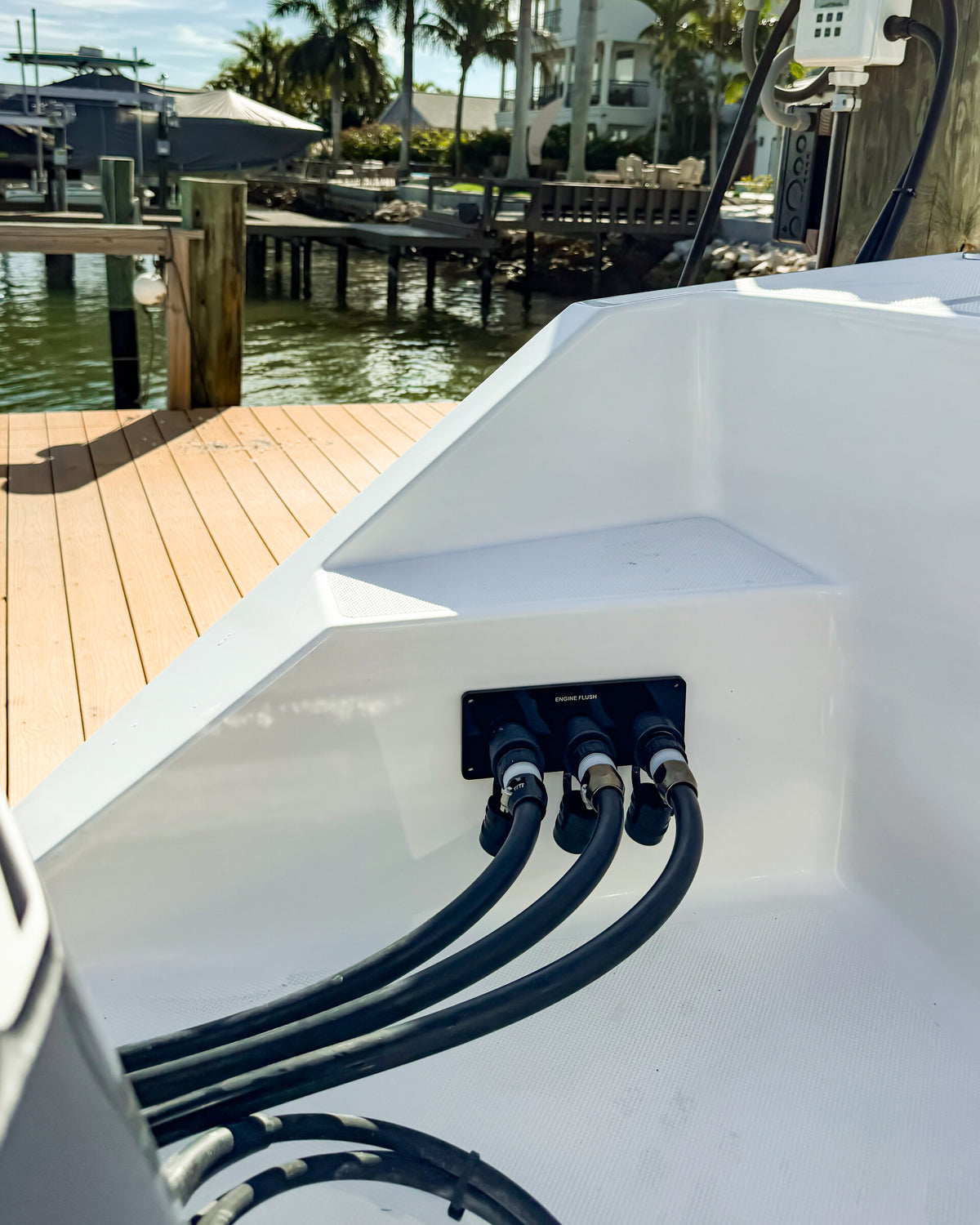 Triple black Flush Port Reroute mounted horizontally on a boat with three separate controller hoses connected.