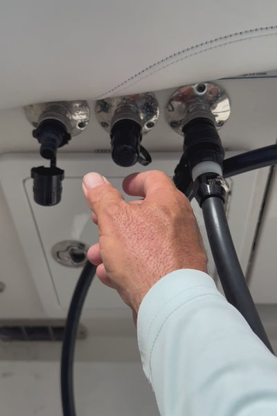 man using flush port quick connect for suzuki on standard water fittings to flush rerouted triple yamahas