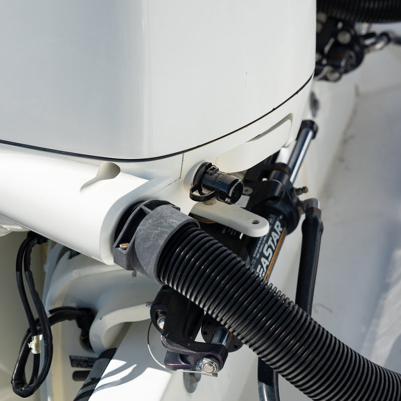 close up of flush port quick connect for suzuki on white engine