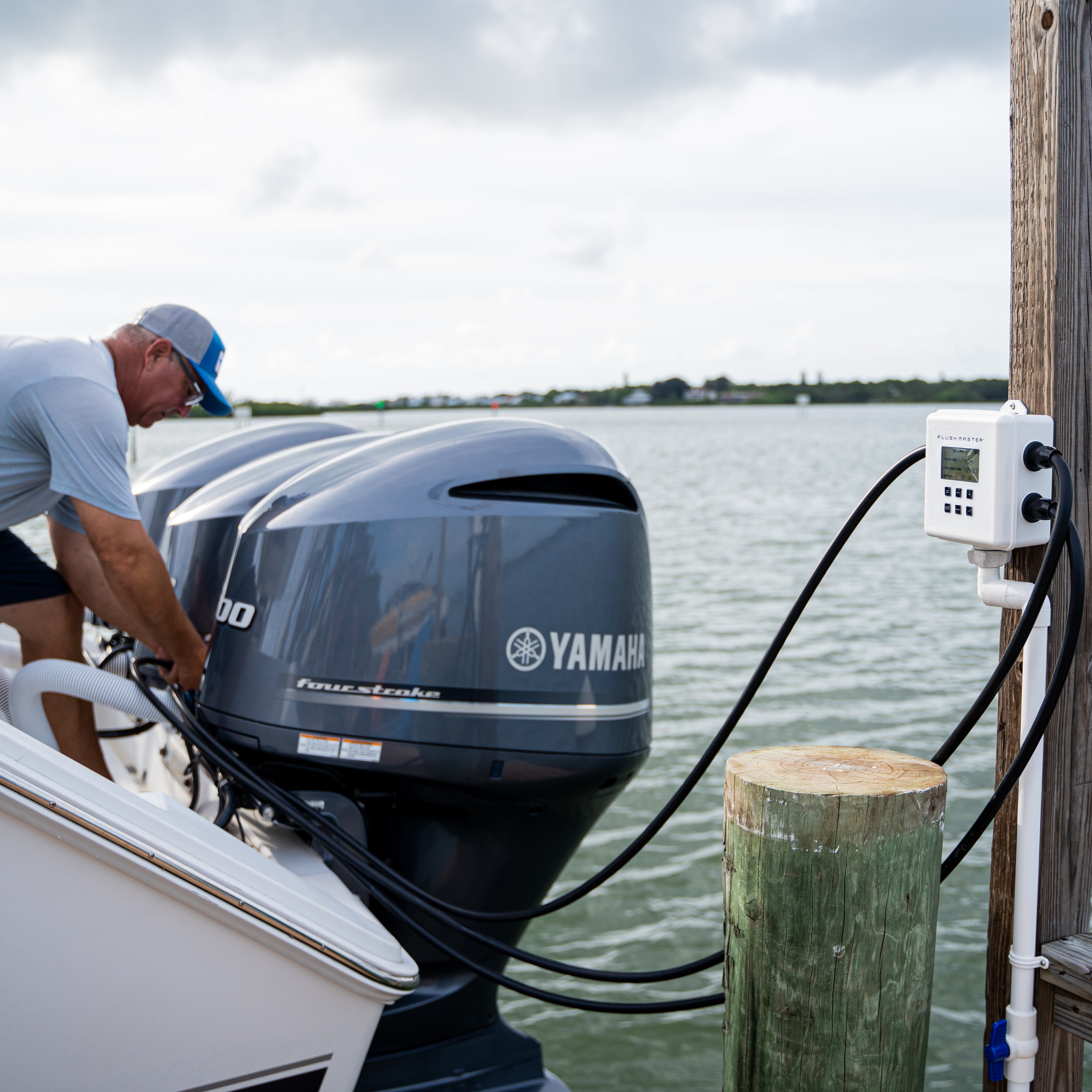 man flushing triple yamaha outboards with flushmaster